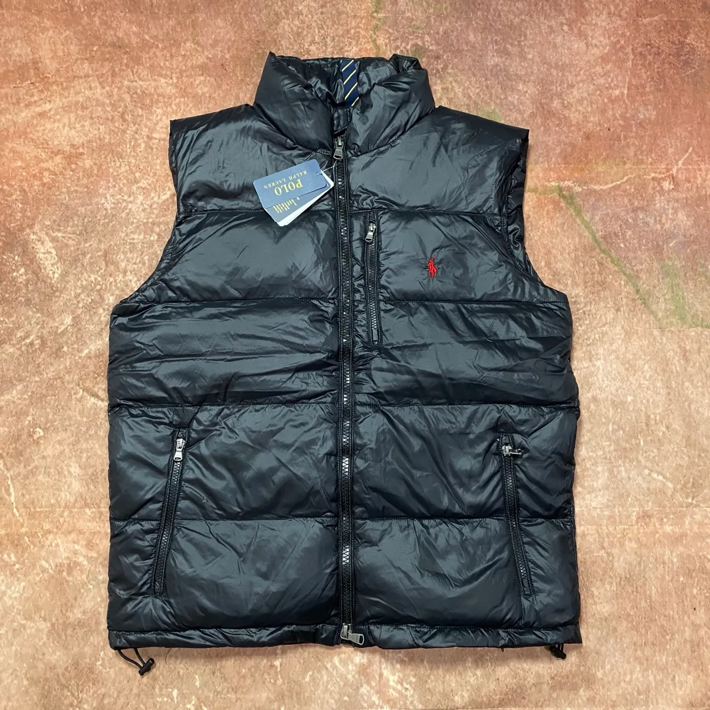 P560 Rah Lauren embroidered down vest (top version of pure down) 100% pure down, a classic and evergreen style, the same model used by celebrities and internet celebrities to keep out the cold, made from fabrics, fillings to auxiliary materials, all-round benchmarking against the original quality. It uses an imported Behringer embroidery machine, 10,000-needle electric embroidery technology, and imported No. 7 needles and embroidery thread to create a full, three-dimensional, clear-textured polo logo on the chest, which can be called a "moving texture badge." Double-layer locked velvet interior, bid farewell to the worry of velvet running away. The inner lining adopts a nylon double-layer sealed velvet structure to strictly prevent velvet drilling. The hem has a built-in adjustable drawstring, making it more windproof and cold-proof. Paired with customized size 8 YKK zipper, a must-have item for autumn and winter. Color Black, Navy Blue, Black Glossy Size m-xxl